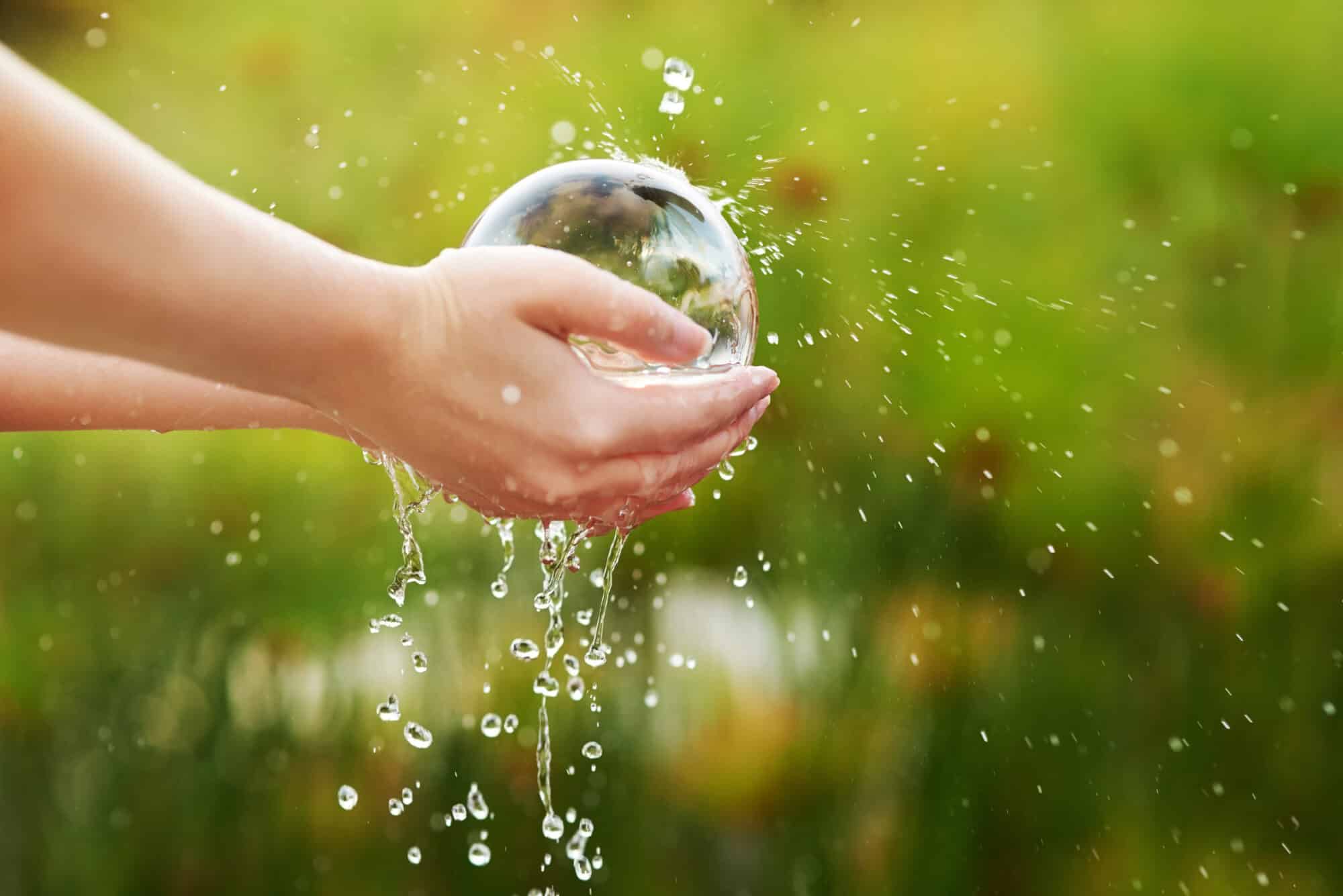 Closeup shot of hands held out under a stream of water